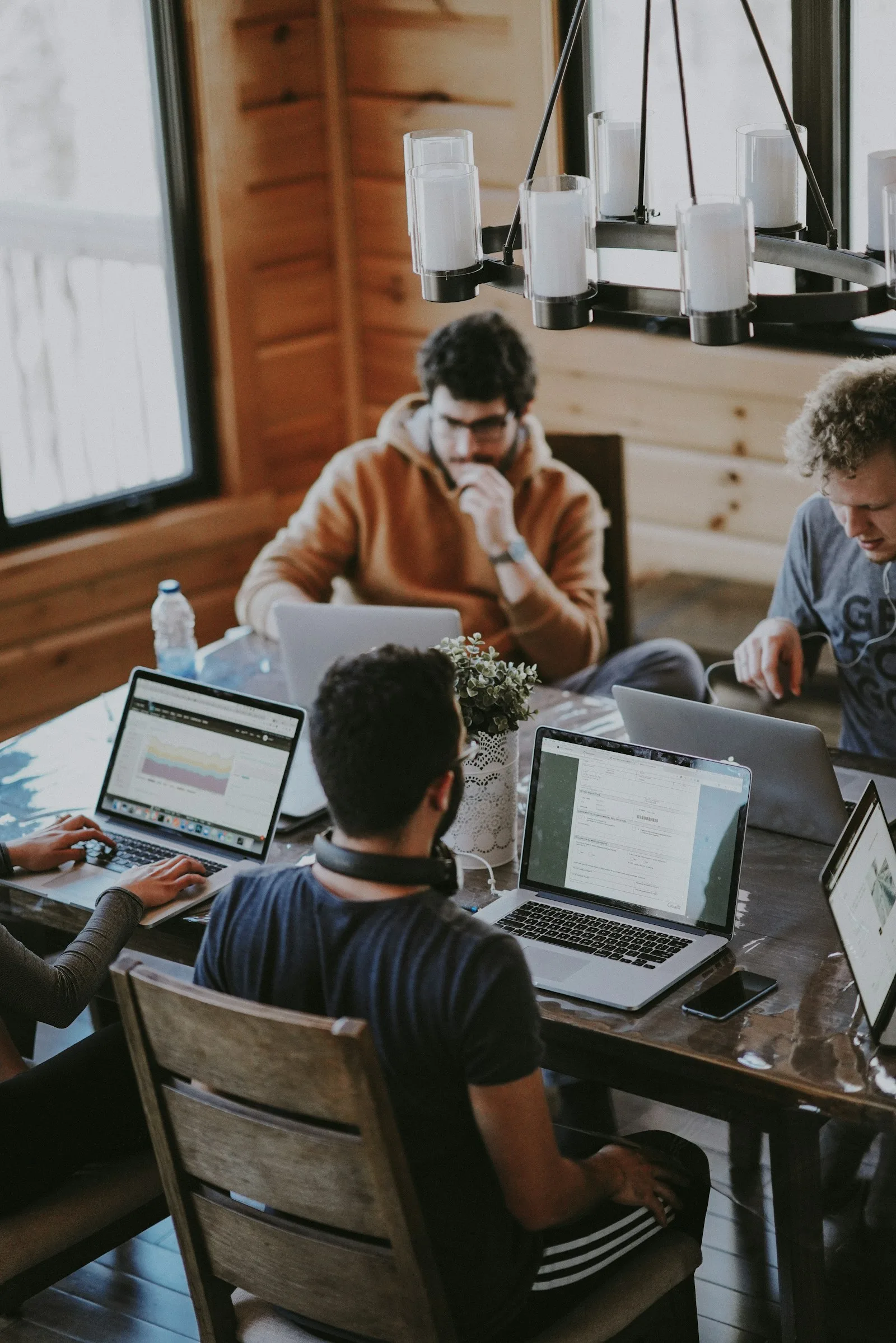 Aanloop AI team aan tafel met laptops — neem contact op met onze AI-experts in Rotterdam