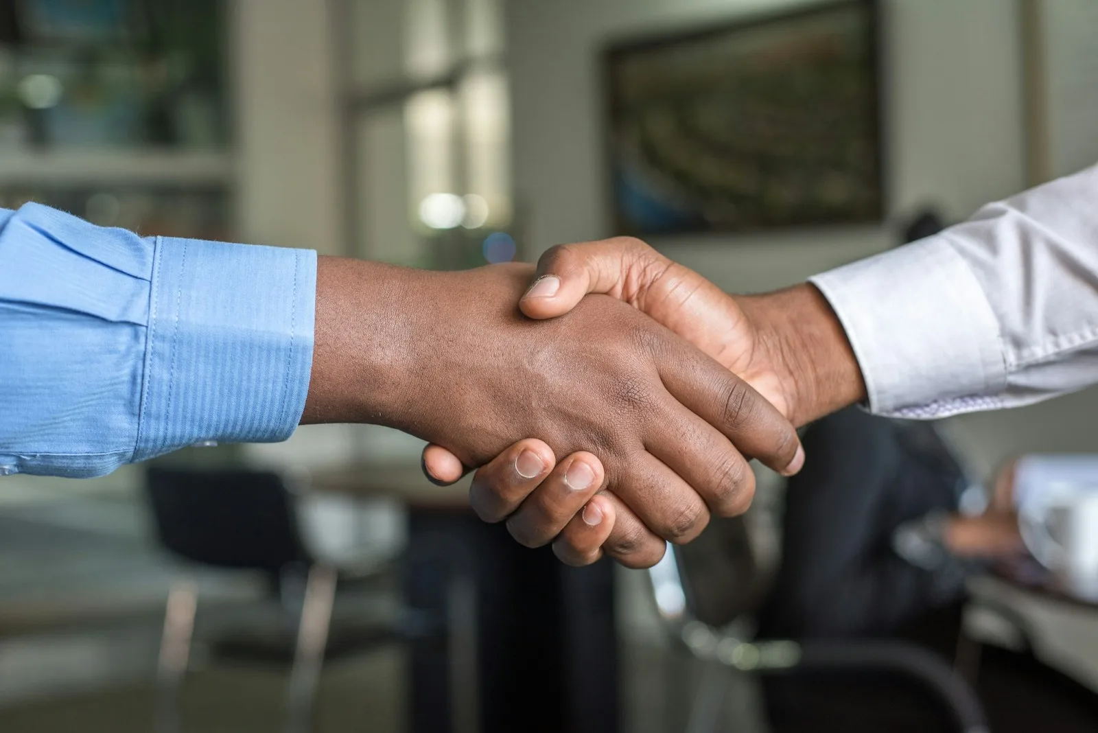 Zakelijke handdruk in moderne kantooromgeving — AI verkoopagent voor outbound sales
