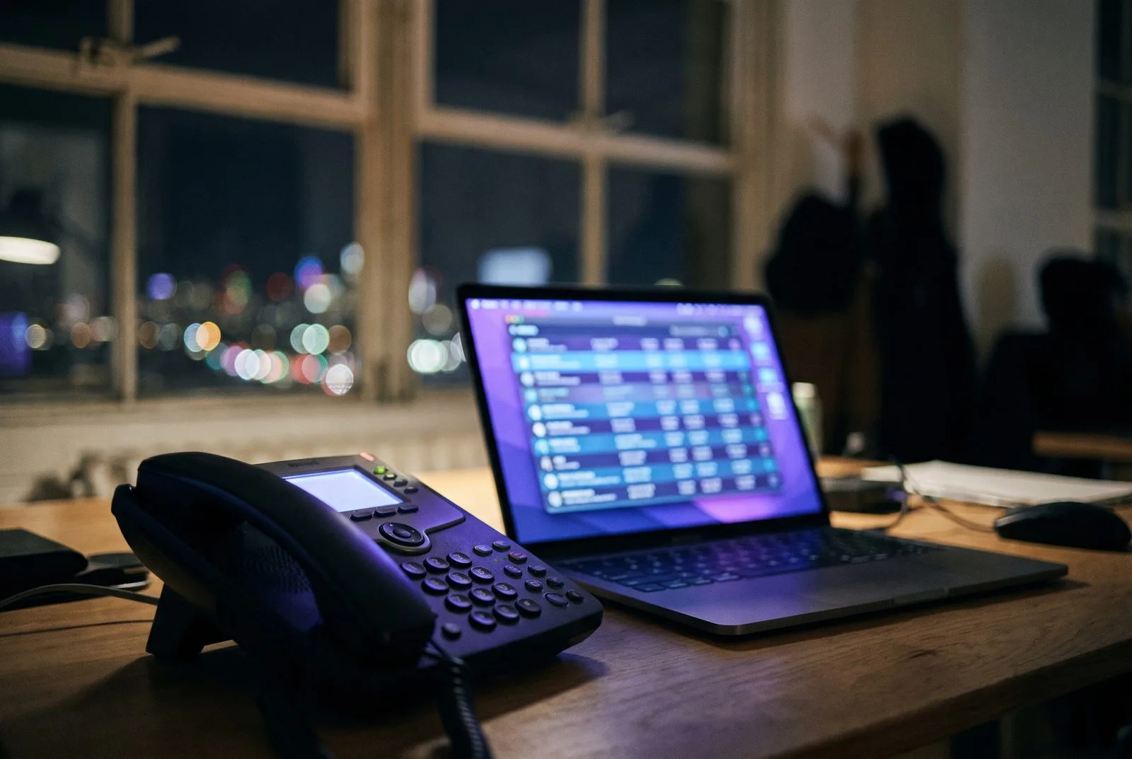 Avondkantoor met bureautelefoon en laptop met AI-bellijst — AI verkoopagent voor outbound sales