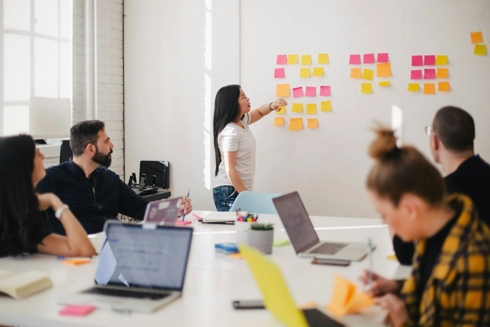 Team brainstormt rond whiteboard met sticky notes — Aanloop AI werkwijze van adviesgesprek tot live AI-agent